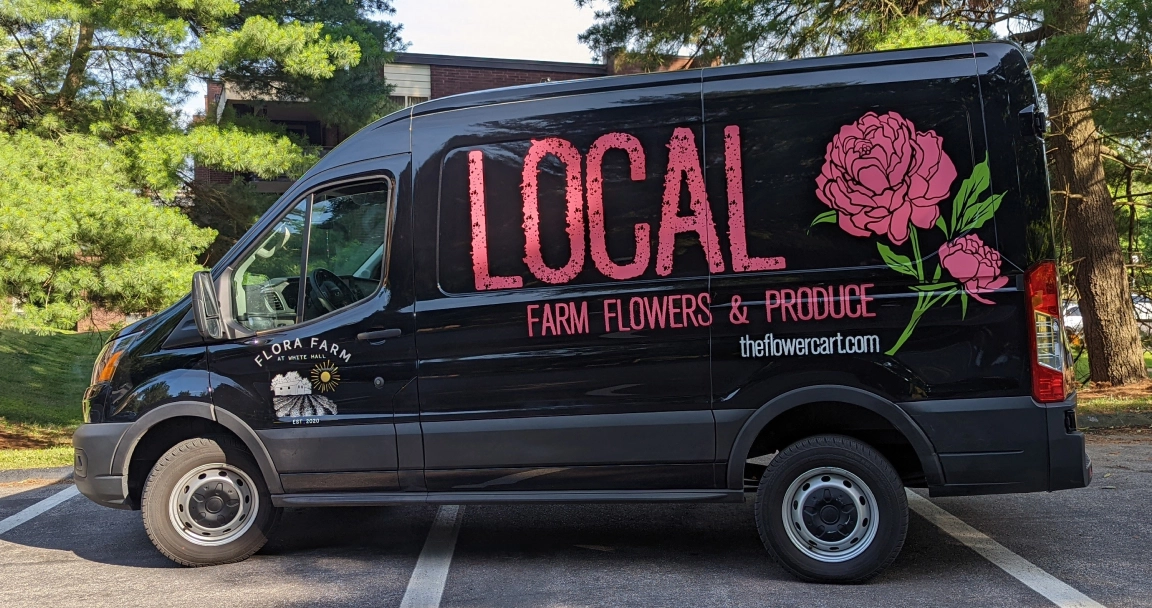 Local farm flowers wrapped van with large rose and logo on black vehicle